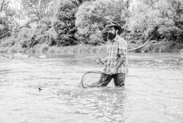 Hobby di pesca. Barbuto brutale pescatore cattura pesce trota con rete. La pesca è uno sport all'aperto ricreativo accessibile stupefacente. Se il pesce regolarmente si sa come la pesca gratificante e rilassante è — Foto Stock