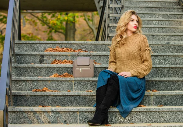 Vrouw met prachtig kapsel zit buiten op de trap. Herfst mode trend. Lagen oversize brei over meisjesrok. Draagbare trends. Herfst outfit formule. Hoe stijl trui en rok Combo voor herfst — Stockfoto