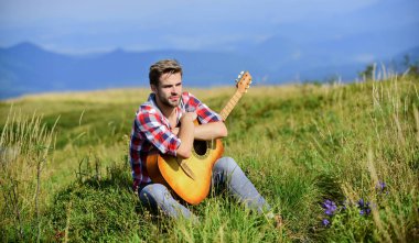 Seyahat tutkusu konsepti. İlham verici bir doğa. Yaz tatili doğada var. İlham arayan bir müzisyen. Hayalperest gezgin. Tek başına iyi vakit geçirdin. Huzurlu bir ruh hali. Gitarlı adam doğayı düşünüyor.