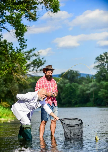 Homem barbudo e pesca brutal hipster. Equipa de pesca. Amigos a pescar peixe. Hobby e recreação. Pescando peixe com alma gêmea. Paz de espírito e tranquilidade. Peixe de água doce. Dia activo. Dia da família — Fotografia de Stock