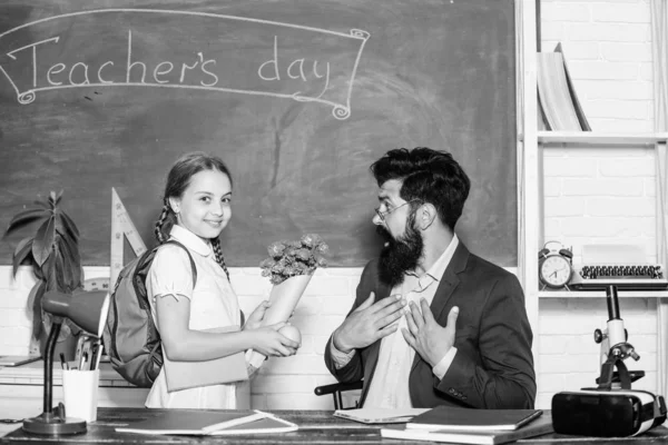 Saudações para o pedagogo da escola. Férias escolares. Aluna agradecida. De volta à escola. Felicidades. Menina aluno adorável com mochila dando professor de flores de buquê. Congratulações de dia de conhecimento — Fotografia de Stock