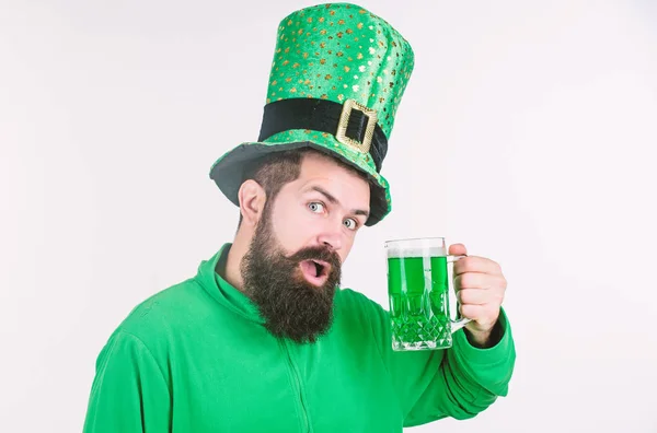 En höjning av gröna. Hipster i leprechaun hatt hålla ölglas. Firar saint patricks dag i bar. Skäggig man skåla för att saint patricks dag. Irländska mannen med skägg dricka Grön öl — Stockfoto