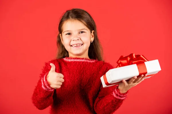 Día de boxeo. Una niña pequeña sostiene la caja de regalo. Niño mantenga la caja actual fondo rojo. Centro comercial. Chica del cumpleaños. Feliz Navidad y felices fiestas. Compras de regalos de Navidad. Paquete regalo. Sueños preciados —  Fotos de Stock