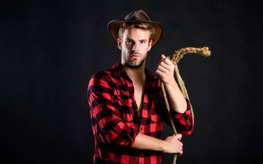 Haydut mu? Batı kovboy portresi. Çiftlikte kareli gömlek. Klasik tarz adam. Vahşi Batı eski kovboy. Kement ipli bir kovboy. Batı. Vahşi batı rodeosu. Siyah şapkalı adam.