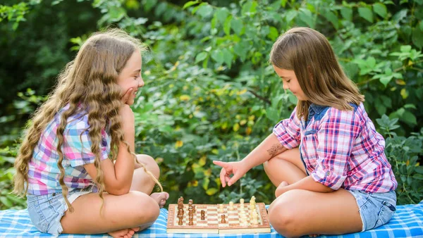 Sport et concept de passe-temps. Les petites filles jouent aux échecs. Des soeurs qui jouent aux échecs. Développement cognitif. Jeu intellectuel. Prendre une décision. Des enfants intelligents. Les enfants jouent aux échecs en plein air nature arrière-plan — Photo