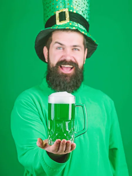 Celebrando el día de San Patricio en el pub de cerveza. Un irlandés con barba bebiendo cerveza verde. Un hombre barbudo brindando por el día de San Patricio. Hipster en sombrero de duende sosteniendo taza de cerveza. Verde y frío — Foto de Stock