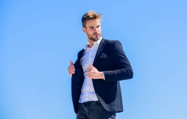 Moda dükkanı. Genç girişimci iş adamı. Sakallı hippi. İşadamı mavi gökyüzüne karşı. Gelecekteki başarı. Erkek modası. Sakallı adam. Başarılı bir iş adamı. Yakışıklı adam takım elbise giyiyor.