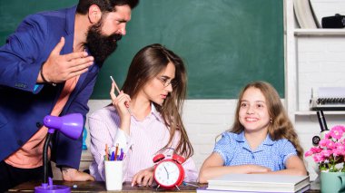 Aşırı korumacı ebeveynlik tarzı. Ödev yapan küçük bir kız. Baba anne çocuğa öğretiyor. Zeki bir aile. Aşırı korumacı ebeveynlik tarzının en büyük dezavantajı yetersiz hazırlanmış çocuklar. Aşırı korumacı aile