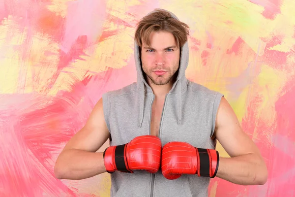 Guy in grey sleeveless hoodie wears red boxing gloves — Stock Photo, Image