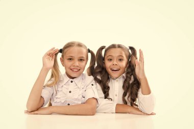 Liseli kızlar masa başı beyaz arka planda otururlar. Liseli kızlar duygusal arkadaşlar. Okula dönelim. Eğitim konsepti. Güzel kızlar en iyi arkadaşlar. Sevimli liseli kızlar. Resmi tarz. Mutlu çocukluk