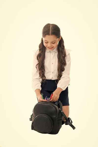 Dingen dragen in een rugzak. Maak je klaar. Past goed in de rugzak. Meisje kleine modieuze cutie dragen rugzak. Populaire nuttige mode accessoire. Schoolmeisje paardenstaarten kapsel met kleine rugzak — Stockfoto