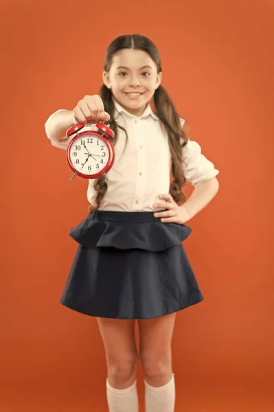 Schoolgirl child formal uniform hold alarm clock. Time to study. Classes begin. Developing discipline. Time for break and relax. Vacation time. Elementary school day bell schedule. Schooltime concept — Stock Photo, Image