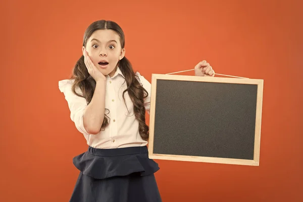 O jee. verraste leerling in school uniform. Kopieer ruimte. commerciële marketing conept. Business School advertentie. nieuw winkel idee. verkoop op de school markt. Signage. verrast schoolmeisje met Blackboard — Stockfoto