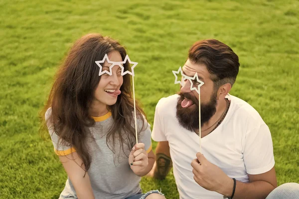 Fun ötleteket. Vicces pár szerelmes pihentető zöld fű. Boldog pár szórakozik a kellék szemüveg botok. Érzéki nő és szakállas férfi élvezi szórakozás együtt. Photobooth szórakozás — Stock Fotó