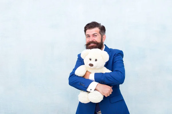 Zijn favoriete speelgoedvriend. Gelukkig zakenman knuffel teddy beer blauwe achtergrond. Baard man glimlach met speelgoed vriend. Vriend en vriendschap. Adoptie en adoptie ouder. Perfecte liefhebbende vriend, kopieer ruimte — Stockfoto