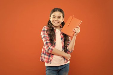 Bilgiye doğru. şiir ve roman. modern eğitim. okul kız turuncu arka plan kitap okuyun. edebiyat dersi. Okula geri dön. notlar yazma. çocuk günlüğü. dizüstü bilgisayar ile mutlu küçük kız