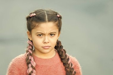 Şüpheli bir bakış. Saç örgülü pembe kanekalonlu kız. Kuaför salonu. Örülmüş şirin şey. Şirin örgüleri olan küçük bir kız. Kanekalon çocuk örgüsü. Saç stili konsepti.