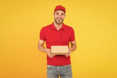 Kurye servis teslimatı. Satıcı ve kurye kariyeri. Kurye ve teslimat hizmeti. Postacı teslim işçisi. Mutlu adam sonrası paket sarı arka plan. Satın alma işlemini teslim etmek. Tatil için hediyeler