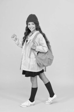 Çocukların iş yüküne en iyi uyan sırt çantası. Sonbahar tatilinde sırt çantalı küçük bir kız seyahat ediyor. Küçük çocuk sarı arka planda okul çantası takıyor. Sırt çantası çok rahat.