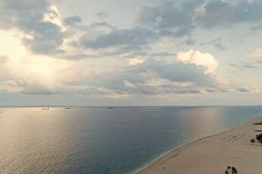 Deniz kenarında bulutlu bir gün. Pürüzsüz okyanus su yüzeyinin üzerindeki beyaz bulutlar. Sakin kavram. Sakin deniz akşamı. Yaz tatili destinasyonları. Deniz plajında dinlenin. Seyahat ve wanderlust. Çarpıcı güzellik