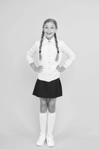 Självsäker examen. Grabbmode. Skolmarknaden. Kunskapsdag. barndoms lycka. utbildningskoncept. Tillbaka till skolan. smart liten flicka på gul bakgrund. lycklig flicka i skoluniform — Stockfoto