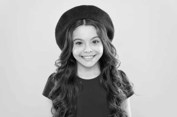 Infancia. peluquería. moda de verano y belleza. niño parisino sobre fondo amarillo. chica feliz con el pelo rizado largo en boina. Niña en sombrero de estilo francés. Retrato de moda de niña —  Fotos de Stock