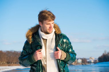 Kış tatili Yürüyen karlı doğa arka planı. Adam ocak ayının tadını çıkarıyor. Eğlence konsepti. Aktif boş zaman. Kışın seyahat eden yakışıklı bir adam. Soğuk mevsim için sıcak kıyafetler. Kış modası