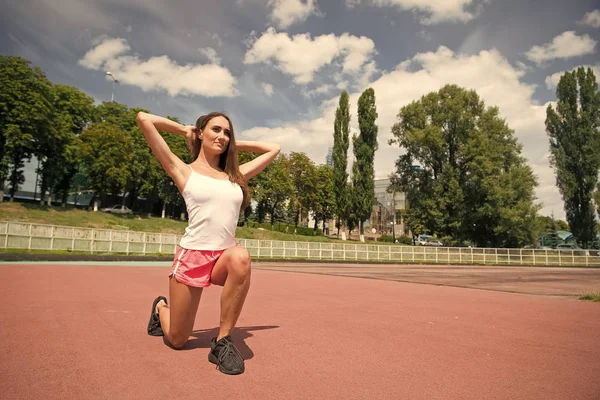 Fuerte es hermoso. Mujer deportiva. Mujer atlética en entrenamiento de ropa deportiva en el estadio. Mujer joven y atractiva disfrutando de actividades de fitness en el día de verano. Una mujer puede hacer cualquier cosa — Foto de Stock