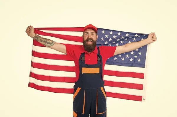 Vlajka USA je proletěla výš než ostatní. Vousatý muž, který drží americkou vlajku na den nezávislosti. Vlastenecký pracovník oslavující den vlajky. Šťastný alternativců v pracovním oblečení s národní vlajkou Spojených států — Stock fotografie