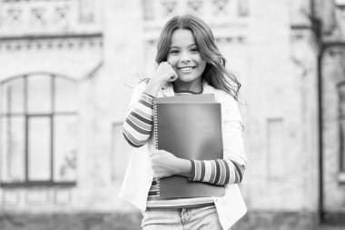 Gülümseyen kız öğrenci ders kitaplarını ders çalışmak için tutuyor. Yetenekli çocuklar için eğitim. Başarılı bir öğrenci. Daha derin öğrenme için ekstra ders alıyorum. Okul eğitimi. Modern eğitim