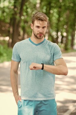 Bilek bandı aleti. Atlet kontrol fitness izci doğa arka plan. Kıllı atlet pedometre gadget ilerleme sonucu bakar. Akıllı saat gadget ile sporcu eğitimi. Modern teknoloji