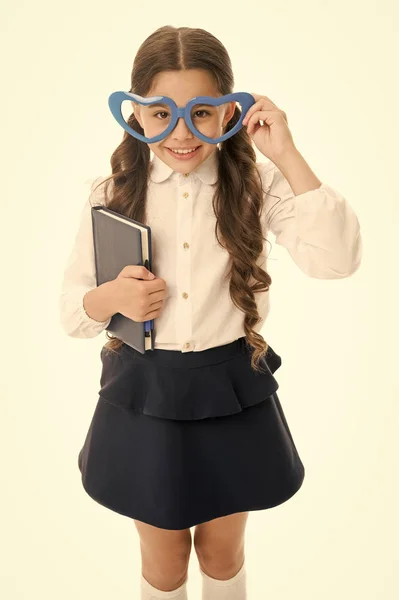 Liebenswerter Bücherwurm. Schulmädchen herzförmige Brille weißen Hintergrund. Kind Mädchen Schuluniform halten Buch. Smart-Kids-Konzept. Verliebt in Bildung. Schulverein. Kinder lernen gern. Schulprojekt — Stockfoto