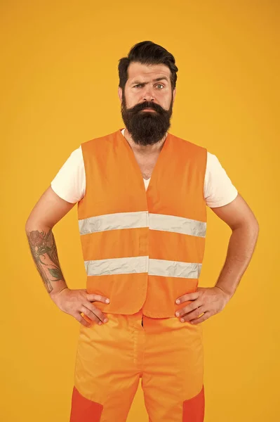 Brutal and professional. Brutal caucasian man with long beard on yellow background. Brutal hipster with tattooed arms wearing work clothes. Bearded worker with brutal look — Stock Photo, Image