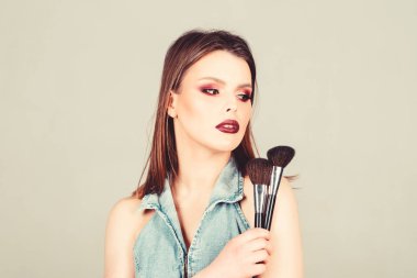 Kadınlığı vurgulayın. Kız pudra göz farı uygulayın. İyi görünmek ve kendinden emin hissetmek. Makyaj koyu dudaklar. Makyaj fırçası uygulayan çekici kadın. Profesyonel makyaj malzemeleri. Makyaj sanatçısı kavramı