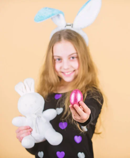 Origen del conejo de Pascua. Símbolos y tradiciones de Pascua. Niño juguetón con juguete suave. Conoce las vacaciones de primavera. Niña niña conejito de Pascua accesorio celebrar huevo teñido. Caza de huevos de Pascua como parte del festival — Foto de Stock