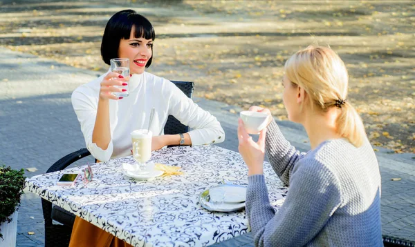 Sharing thoughts. Female friendship. Trustful communication. Girls friends drink coffee and talk. True friendship friendly close relations. Conversation of two women cafe terrace. Friendship meeting