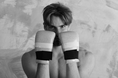 Adam çıplak gövde ile pozisyon savunmak altın boks eldiven giyer. Spor ve savaş kavramı. Martial arts MMA savaşçı uygulamaları