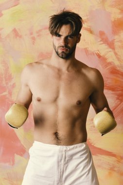 Kendine güvenen yüzü ve renkli bir geçmişi olan bir adam. Spor ve dövüş. Çıplak gövdeli adam boks eldiveni giyiyor.