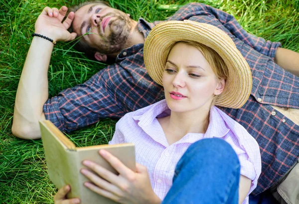 Чоловік і дівчинка лежали на траві читаючи книгу. Пара соратників на романтичному побаченні. Пара закоханих проводить дозвілля читаючи книгу в парку. Сім'я насолоджується дозвіллям з поезією або літературою фону трави — стокове фото