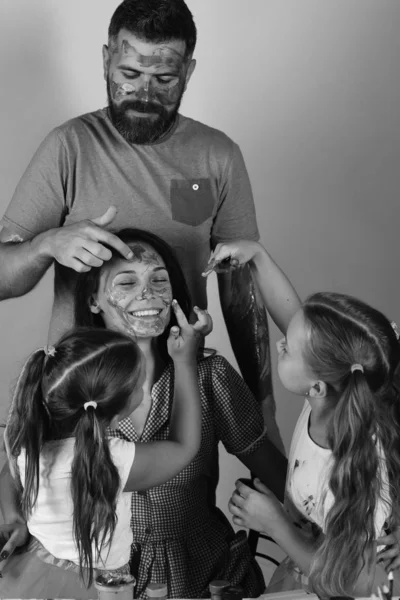 Mädchen, Männer und Frauen mit fröhlichen Gesichtern an ihrem Kunstpult auf blauem Hintergrund. Künstler kreieren Gouache-Kunstwerke auf Damengesicht. Eltern und Kinder — Stockfoto