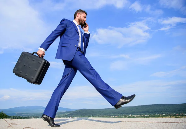 Бизнесмен формальный костюм несет портфель небо фоне. Бизнесмен решает деловые проблемы по телефону. Не останавливайся. Продолжай идти к своей цели. Предприниматель в движении целенаправленное выражение — стоковое фото