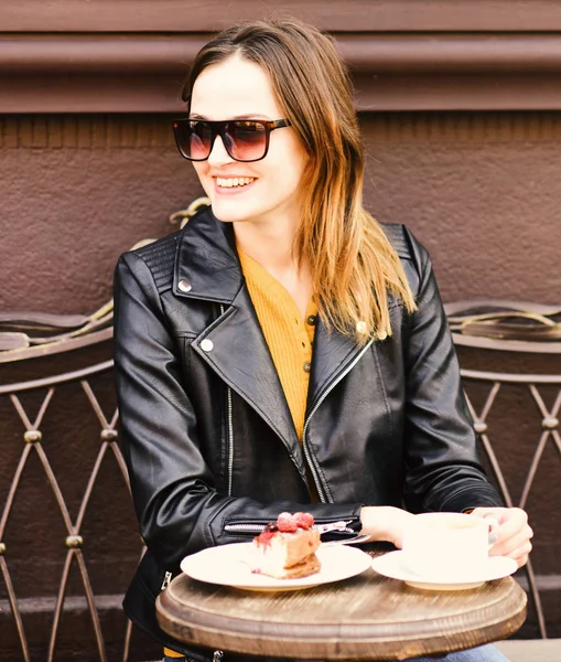Леди пьет кофе во время кофе-брейка. Кондитерские изделия и городской стиль — стоковое фото