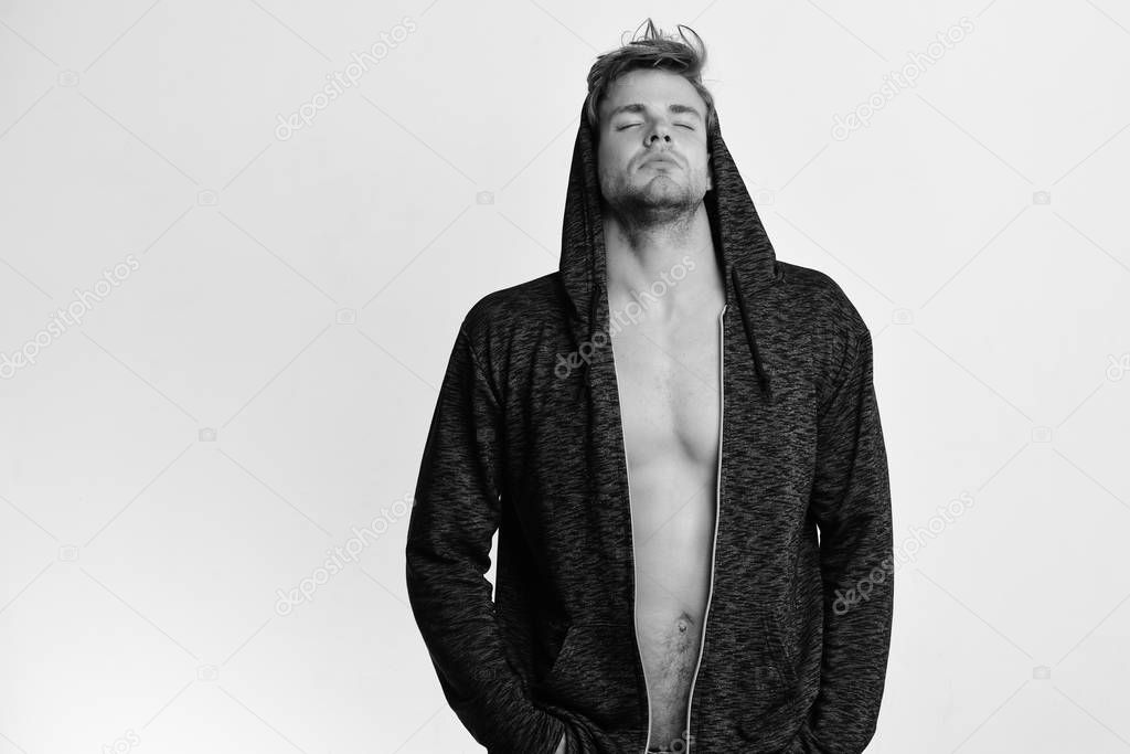 Athlete with messy hair and half naked torso. Fashion and sport lifestyle concept. Man wears dark grey sweater