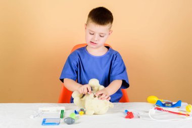 oyuncak tedavisi. Tedavi reçetesi. Çocuk doktoru stajyeri. Tıp üniformalı küçük bir çocuk. Hastane. İlaç ve sağlık. Hemşire laboratuvar asistanı. Aile doktoru. Steteskoplu çocuk doktoru.