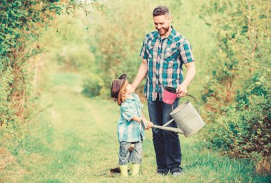 Eko çiftliği. sulama olabilir ve pot kullanın. Bahçe Ekipmanları. küçük çocuk çocuk çiftçilik baba yardım. çiftlikte kovboy şapkalı baba ve oğul. mutlu dünya günü. Aile ağacı emzirme. Bizim küre en iyi