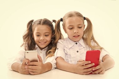 Zeki öğrenciler. Küçük öğrencilerin ders sırasında mesaj atması beyaza izole edilmiş. Akıllı telefon derslerine dalan tatlı lyceum öğrencileri. Sınıfta cep telefonu kullanan küçük öğrenciler