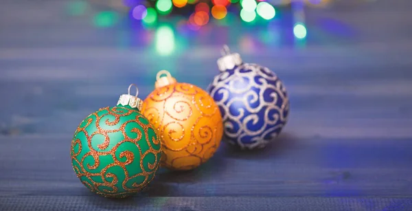 新年とクリスマスの休日のシンボル。様々なクリスマスの装飾。伝統的なおもちゃでクリスマスツリーを飾る。青い木製の表面にクリスマスボールの装飾。冬休みのコンセプト — ストック写真