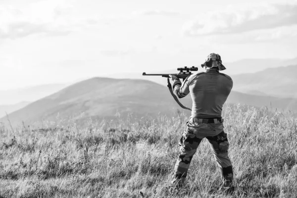 Güzel atış. Av için tüfek. Hunter tüfeği tutuyor. Hunter dağları manzara arka plan. Odak ve konsantrasyon deneyimli avcı. Ordu kuvvetleri. Silahlı adam askeri giysileri. Acımasız savaşçı — Stok fotoğraf