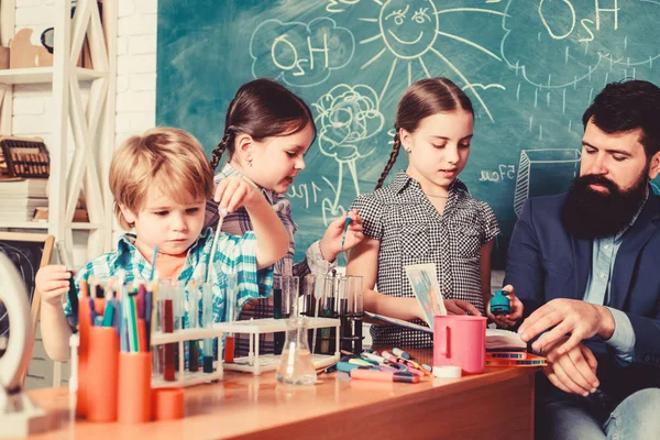 students doing science experiments with microscope in lab. school kids scientist studying science. happy children teacher. back to school. Little kids learning chemistry in school laboratory