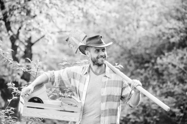 Homme de ranch musclé en chapeau de cow-boy. Ouvrier agricole écologique. Récolte. heureux jour de la terre. Eco living. agriculture et agriculture. Équipement de jardin. agriculteur sexy tenir la pelle et la boîte avec pot. Rendre votre vie colorée — Photo